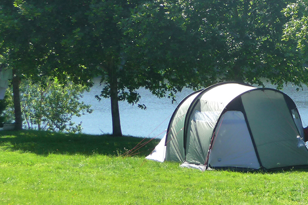 Une tente proche de l’eau au camping